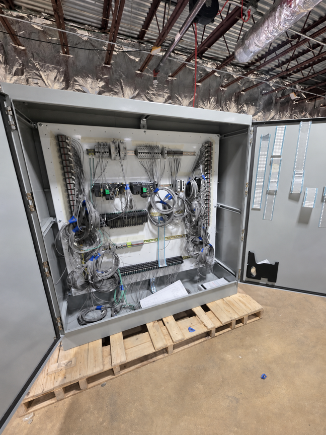 Open electrical control cabinet with wiring in a production environment